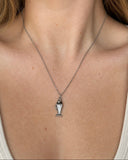 A close-up of a model's neck and chest wearing a delicate silver chain necklace with a small fish-shaped pendant.