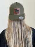Person wearing a green cap with a horse logo on a plain background